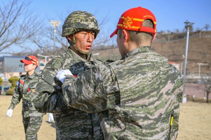 지난 13일 해병대교육훈련단에서 1학년 학군부사관후보생들이 천자봉 고지정복 훈련을 완수한 뒤 빨간 명찰을 수여받고 있다. 사진 제공=이민주 중사(진)