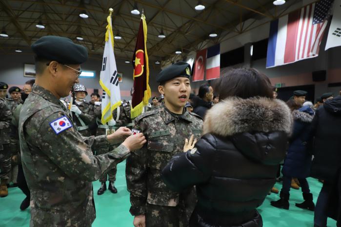 육군36보병사단이 21일 개최한 올해 첫 신병 수료식에서 한 신병의 부모님이 계급장을 달아주고 있다.