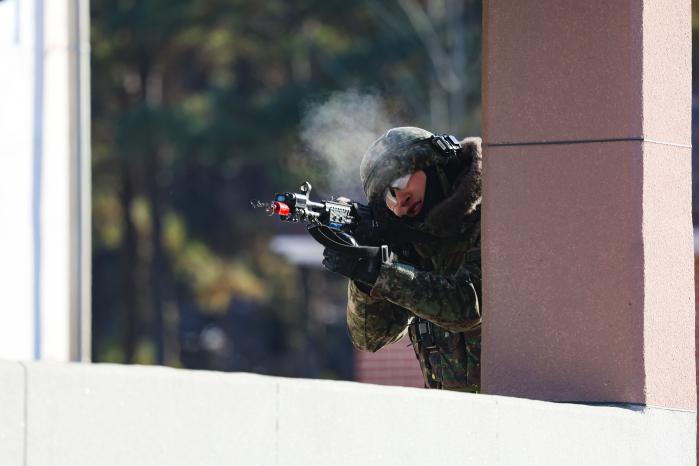 마일즈 장비를 착용한 육군수도기계화보병사단 돌진대대 장병이 20일 경기 파주시 도시지역 전투훈련장에서 열린 쌍방교전훈련 중 적을 조준하고 있다.