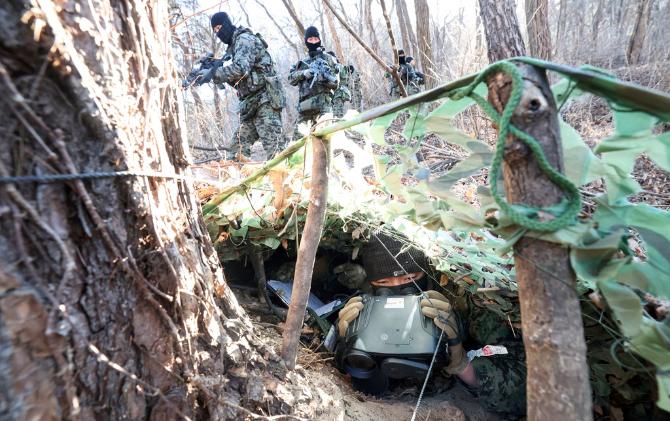 지난 22일 육군특전사 황금박쥐부대 대대급 쌍방 혹한기 전술훈련 현장에서 버팔로대대 작전팀이 구축한 은거지 주위를 대항군이 지나가고 있다. 은거지에 몸을 숨긴 안태길 중사가 숨죽인 채 대기하고 있다.