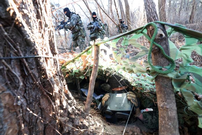 지난 22일 육군특전사 황금박쥐부대 대대급 쌍방 혹한기 전술훈련 현장에서 버팔로대대 작전팀이 구축한 은거지 주위를 대항군이 지나가고 있다. 은거지에 몸을 숨긴 안태길 중사가 숨죽인 채 대기하고 있다.