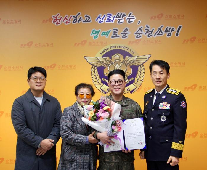 화재 현장에서 시민의 생명을 구한 육군31보병사단 박회민(오른쪽 둘째) 대위가 순천소방서장으로부터 감사패를 받은 뒤 가족과 기념촬영을 하고 있다. 부대 제공
