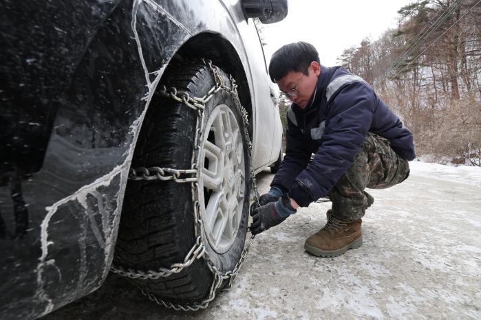 권구원 수송반장이 차량에 스노 체인을 결속하고 있다