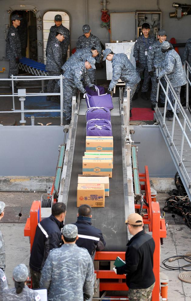 컨베이어 벨트로 대청함에 보급품을 전달하는 장병들.