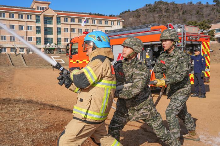 27일 백령도 일대에서 열린 해병대6여단 61대대 관·군 합동 화재진압 훈련에서 부대 자위소방대 장병들과 백령 119안전센터 소방요원이 함께 화재를 진압하고 있다. 사진 제공=김예닮 상병