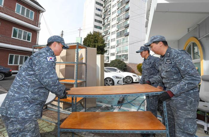 28일 진해희망의집을 방문한 해군진해기지사령부 참수리 336호정 장병들이 노후 가구를 옮기고 있다. 부대 제공