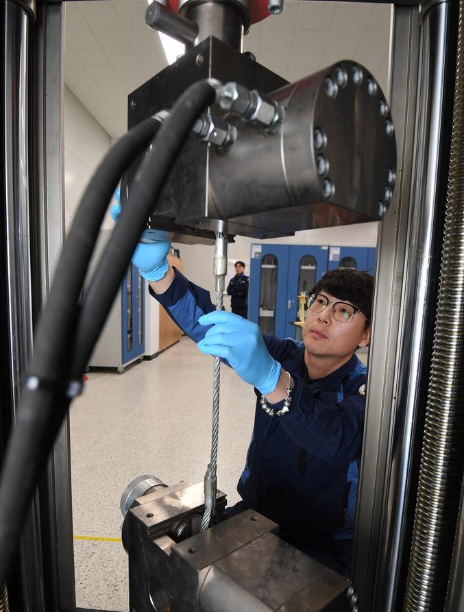 표준측정시험소에서 한 군무주무관이 인장검사기를 활용해 와이어로프 인장검사를 준비하고 있다.