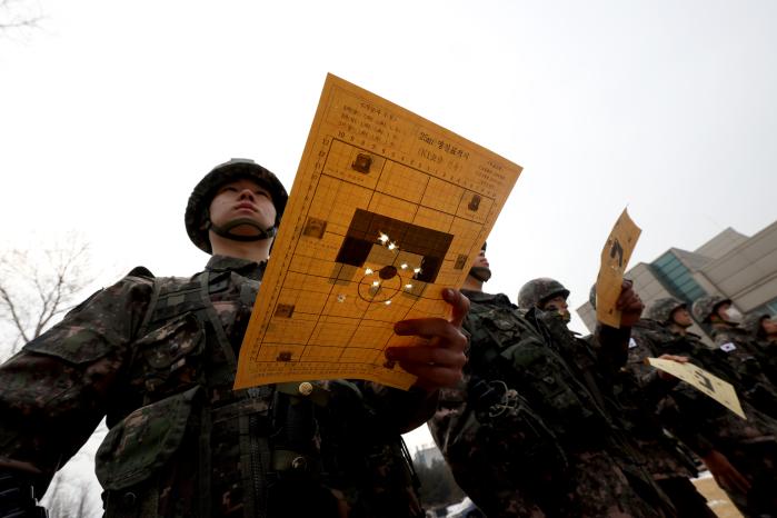 영점사격 표적지를 들고 대기하는 모습.