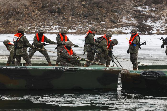 장병들이 교절을 결착하기 위해 양쪽에서 줄을 당기고 있다.