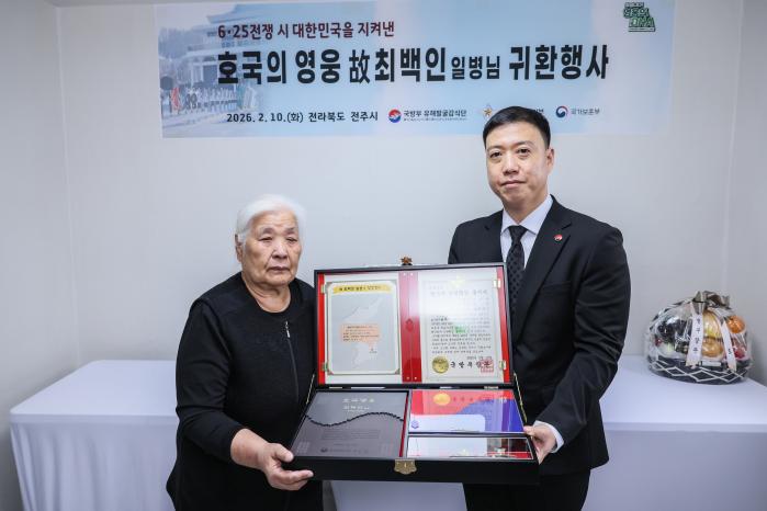 김성환(육군중령·오른쪽) 국유단장 직무대리가 10일 고(故) 최백인 일병의 유가족에게 호국의 얼 함을 전달하고 있다. 부대 제공