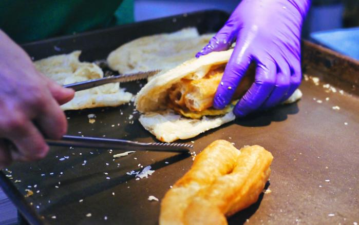 가오슝의 유명한 아침 식당인 ‘흥륜거’에서 요우티아오를 넣은 샤오빙을 만들고 있다.