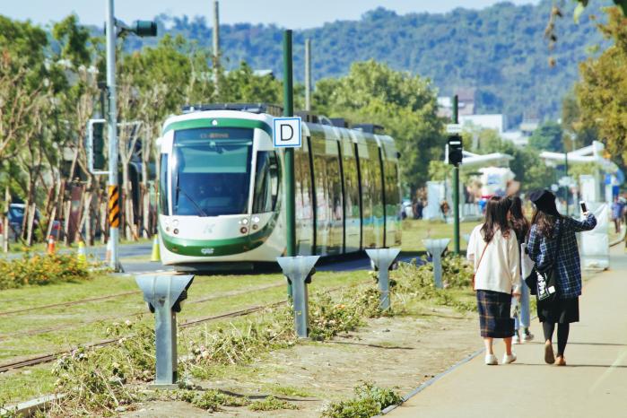 녹색 잔디 위를 달리는 가오슝의 트램.