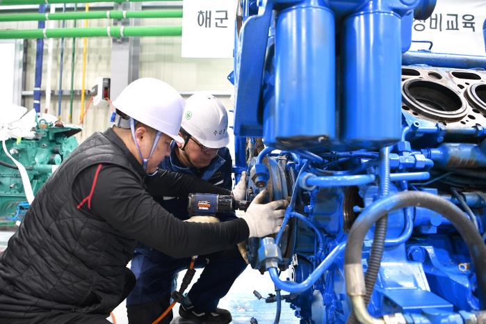 목포해양대학교 선박수리지원센터 소속 전문강사(왼쪽)가 해군3함대 3수리창 정비군무원에게 해군 함정의 ‘MTU 12V 4000’ 고속 디젤엔진 분해 방법을 교육하고 있다. 사진 제공=장효실 상사