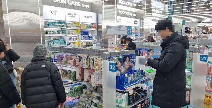 ‘가벼운 소비’의 대표 사례로 꼽히는 다이소 화장품을 사기 위해 물건을 고르는 시민들. 다이소 제공