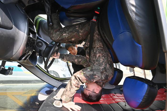 공군군수사령부가 한국교통안전공단 교통안전체험교육센터에서 진행한 안전운전 체험교육에서 실습에 나선 장병이 차량 전복 시 대처 요령을 익히고 있다. 부대 제공