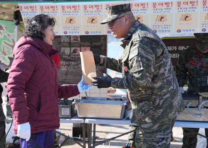 해병대 연평부대 장병들이 지난 17일 연평바다역에서 면회객과 귀성객들에게 붕어빵을 전달한 뒤 함께 포즈를 취하고 있다.