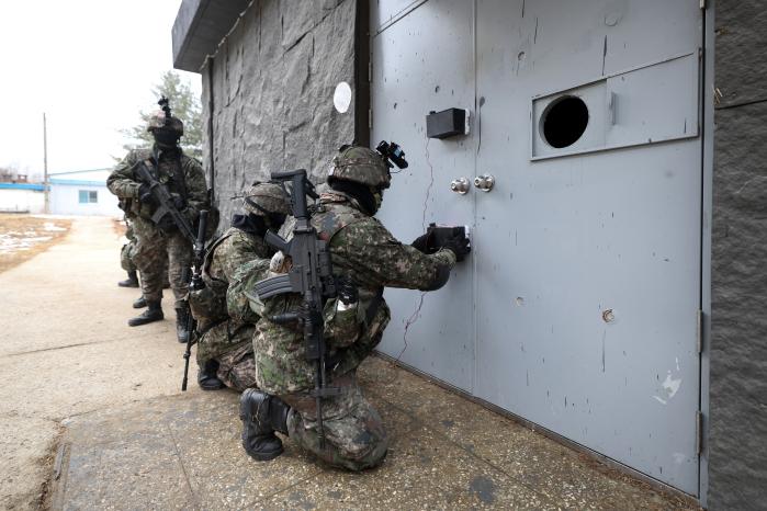 적 시설 침투를 위해 도어 브리칭을 하고 있다.