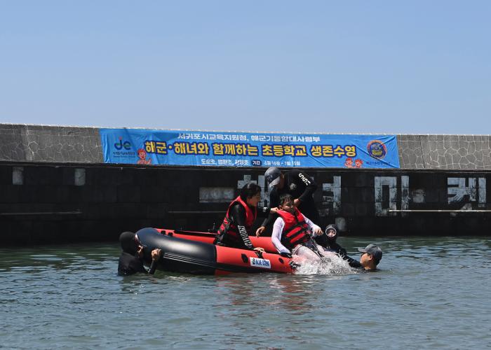 해군기동함대 장병들이 제주지역 초등학생들에게 생존수영을 교육하고 있다. 부대 제공