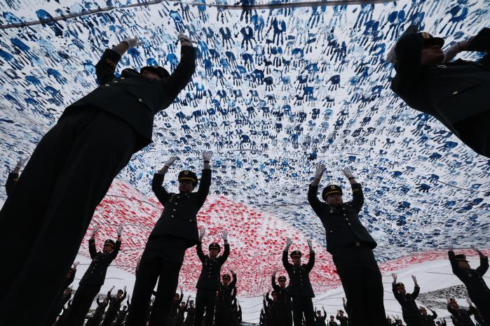 26일 충북 괴산군 육군학생군사학교에서 거행된 ‘2026년 대한민국 학군장교 임관식’에서 신임 장교들이 대형 태극기를 펼쳐 보이는 ‘충성다짐 퍼포먼스’를 하고 있다.