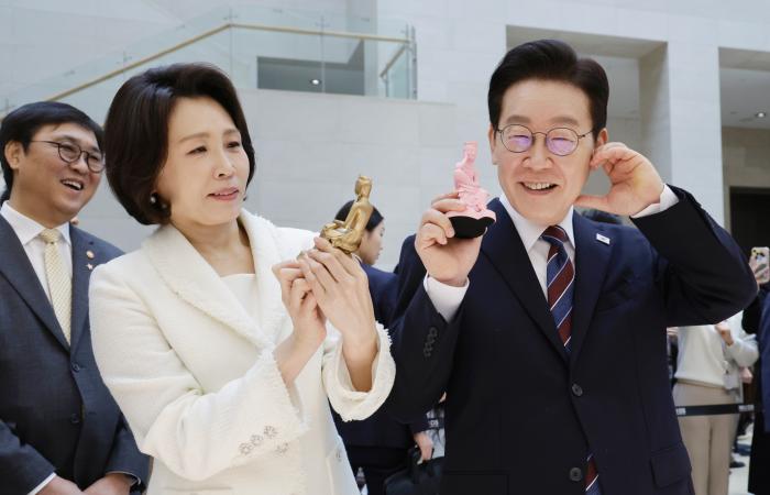 이재명 대통령과 김혜경 여사가 26일 서울 용산구 국립중앙박물관에서 열린 특별전 ‘우리들의 이순신’을 관람한 뒤 상품관에서 기념품과 함께 기념촬영을 하고 있다. 연합뉴스