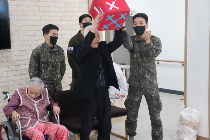 육군2신속대응사단 백호대대 부사관들이 요양원 어르신들과 함께 주사위를 던지며 즐거운 시간을 보내고 있다. 부대 제공