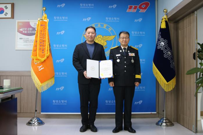 차량에서 발생한 화재를 진압한 육군학생군사학교 이상우(왼쪽) 교관이 횡성소방서장으로부터 표창장을 받고 있다. 사진=부대 제공