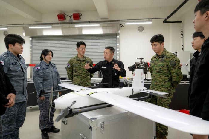 해군교육사령부 해양무인체계교육센터 교육생들이 무인항공체계 교관에게 수직이착륙무인기에 대한 설명을 듣고 있다. 부대 제공