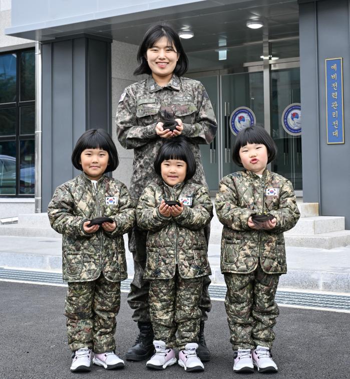 해군8전투훈련단 이은주 상사와 세쌍둥이 딸(왼쪽부터 장은진·소진·유진 양)들이 소아암 환아를 돕기 위해 자른 머리카락을 손에 들고 기념사진을 찍고 있다. 해군 제공