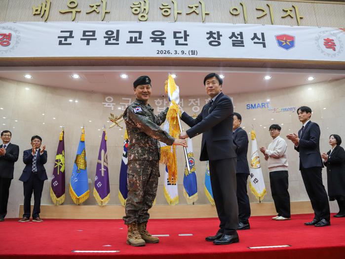 9일 육군종합행정학교에서 열린 군무원교육단 창설식에서 추병대(왼쪽) 학교장이 한유희 군무원교육단장 직무대리에게 부대기를 수여하고 있다. 부대 제공