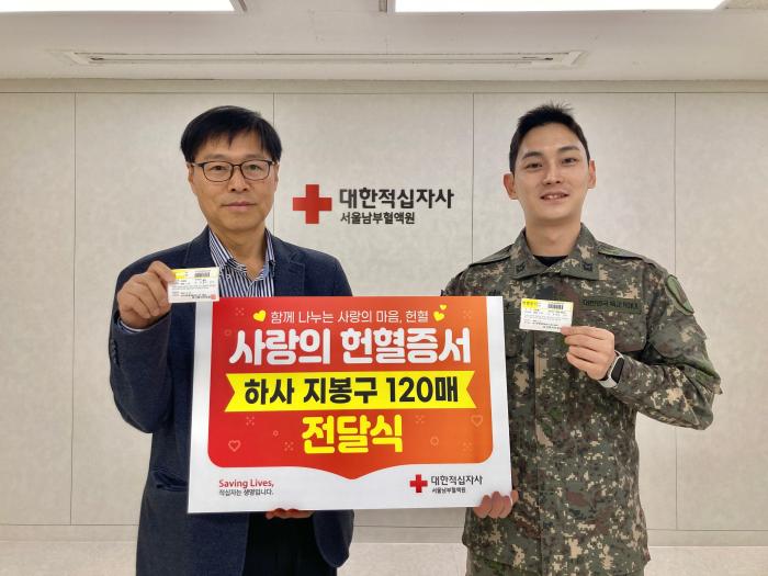 육군수도방위사령부 수호신부대 지봉구(오른쪽) 하사가 13년간 모은 헌혈증 120장을 기부하고 있다.