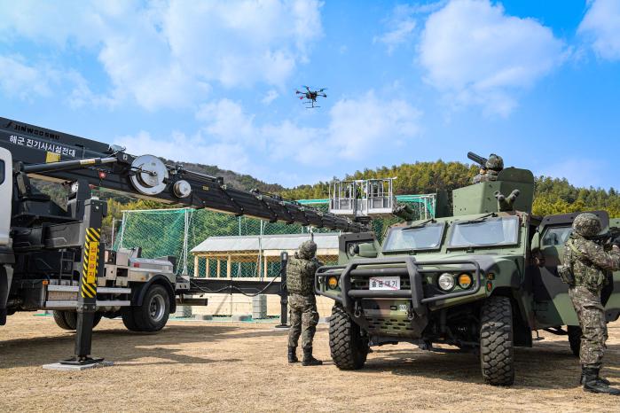 9일 해군진해기지사령부 장병들이 개인 병기와 안티드론건을 활용해 대공경계태세를 강화한 가운데 가상의 중요 시설물에 대드론 네트를 설치한 뒤 대드론 방호훈련을 하고 있다. 사진 제공=권혜연 중사(진)