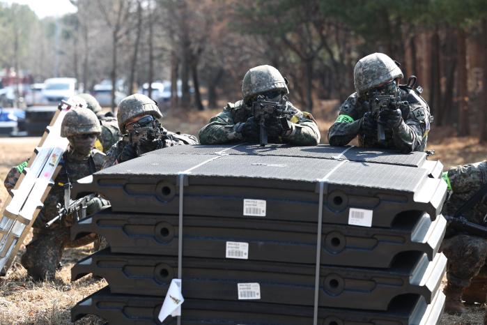 엄폐물을 이용해 경계자세를 취하는 장병들.