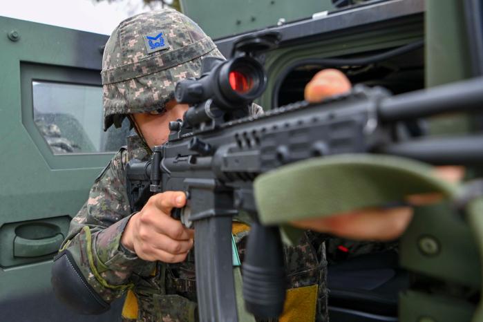 공군1전투비행단 군사경찰 요원이 전투태세훈련의 하나로 이뤄진 대테러 대응훈련에서 테러범을 제압하기 위해 차량에서 나와 경계하며 이동하고 있는 모습. 사진 제공=김시현 하사