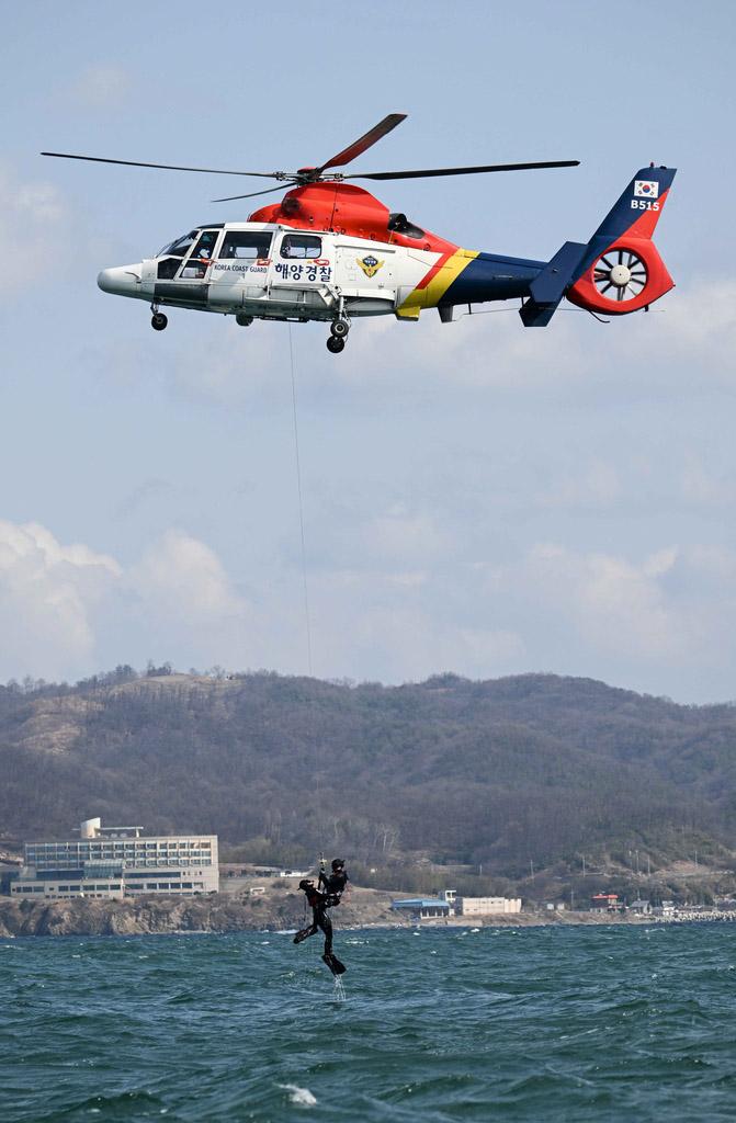 해군특수전전단 해난구조전대가 포항해양경찰서와 진행한 협동 항공구조훈련에서 구조대원들이 호이스트를 활용해 익수자를 구조하고 있다. 부대 제공