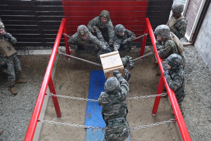 장병들이 장애물 너머로 탄약을 보급하고 있다.