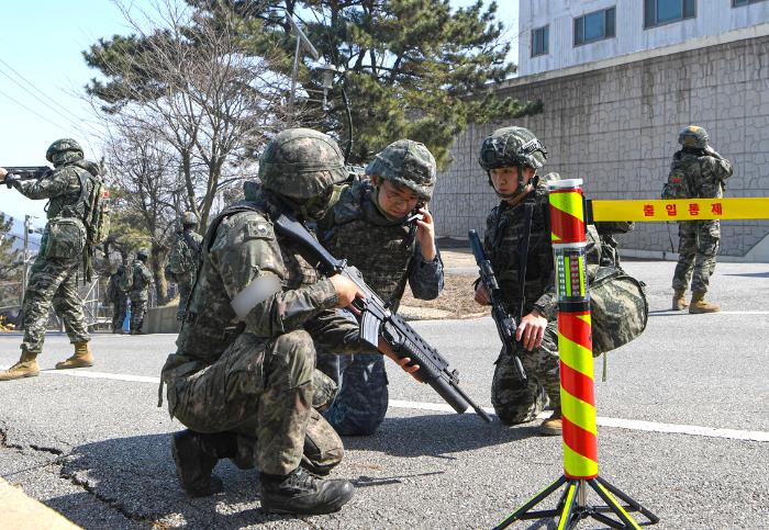 17일 전개된 해군2함대 도서기지 합동 기지방호훈련 중 해군기동타격대와 해병대 5분전투대기소대 대원들이 거동수상자 수색을 위한 통제선을 구축하고 있다. 사진 제공=고예진 중사
