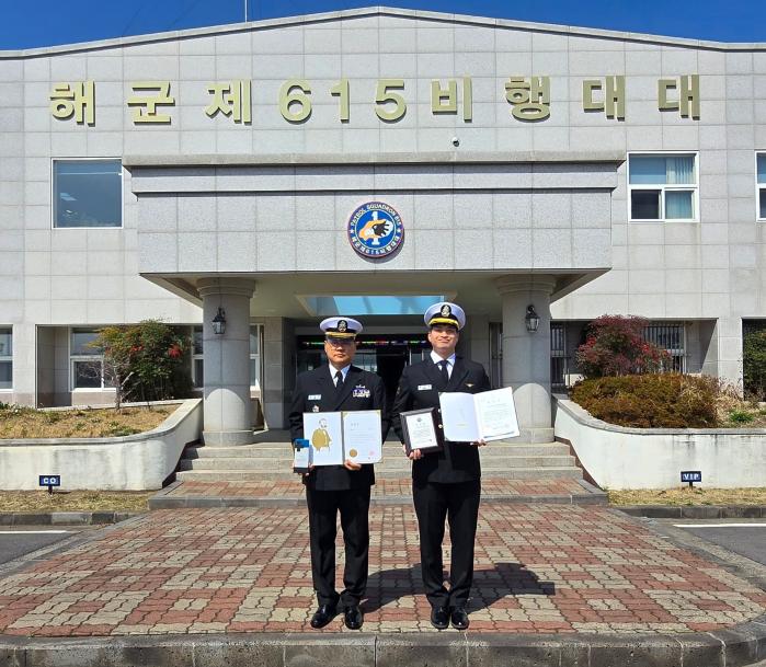 허평진(왼쪽) 상사와 권우혁 중사가 해군항공사령부 615비행대대에서 포장증과 표창장을 들어 보이고 있다. 부대 제공