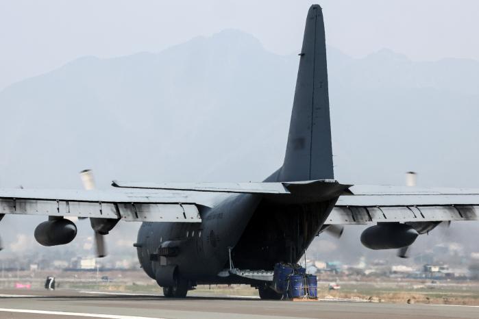 착륙한 수송기가 멈추지 않고 기동하며 활주로에 화물을 투하하는 모습.