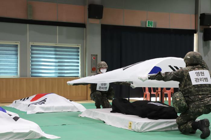 육군36보병사단 장병들이 17일 열린 영현관리소 운영 훈련 중 전공사망자를 모시는 함에 태극기를 도포하고 있다. 부대 제공