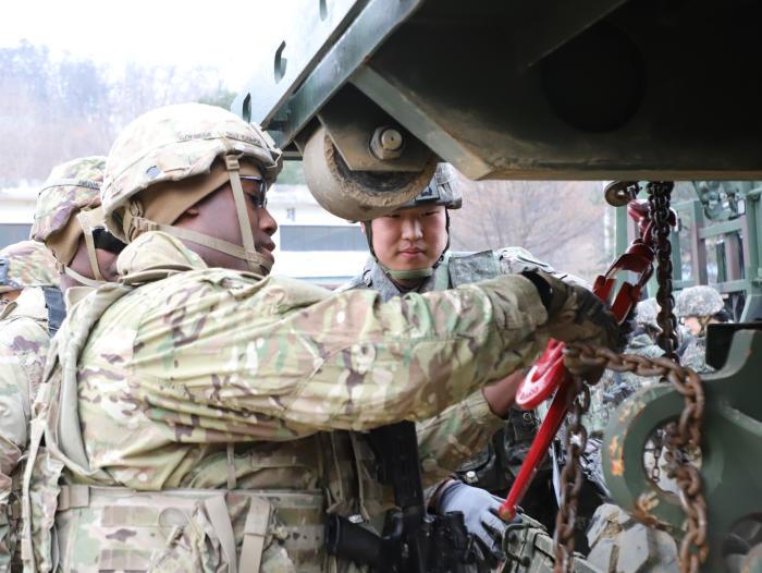 18일 미2사단/한미연합사단·육군1군수지원사령부 연합 군수지원 훈련에서 미군 장병들이 미측 화물 운반 트럭에 우리 측 화물 운반대를 결박해 보고 있다. 부대 제공