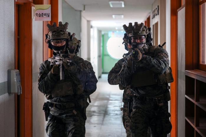 육군특수전사령부 귀성부대 특전대원들이 18일 경기 화성시 한 폐교에서 열린 합동 대테러훈련 중 불법 약물 제조시설에 진입해 내부 소탕 절차를 숙달하고 있다.