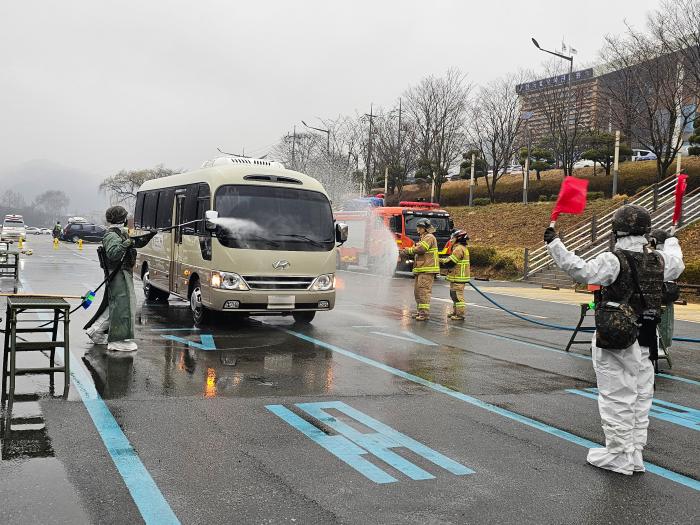 18일 대전시 중구 뿌리공원에서 진행된 핵·WMD 사후관리훈련에서 육군32보병사단 장병과 소방대원이 차량 외부 세척을 하고 있다. 부대 제공