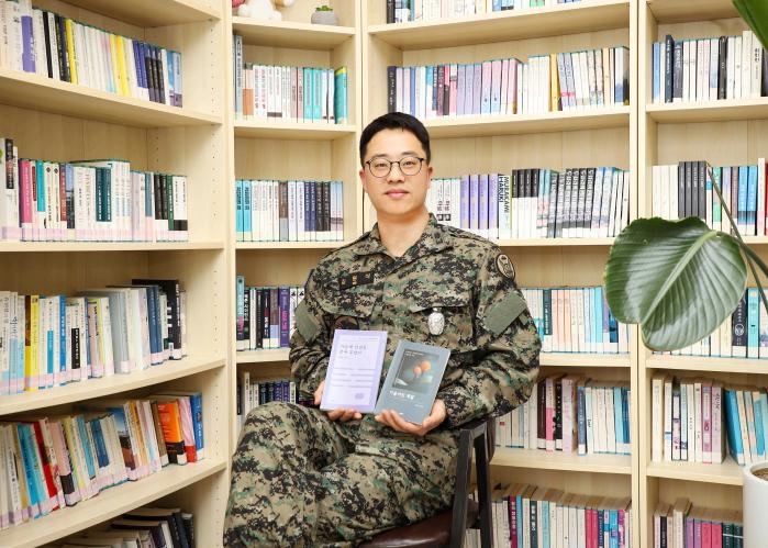 지난해 말 펴낸 산문집 『기울어진 계절』과 시집 『가슴에 안녕을 묻어 두었다』를 들어 보이고 있는 육군특수전사령부 흑표부대 김원식 소령.