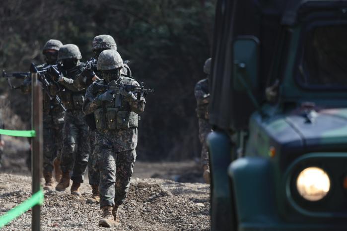 장병들이 지하시설 출입문에 폭약을 설치하기 위해 기동하고 있다.