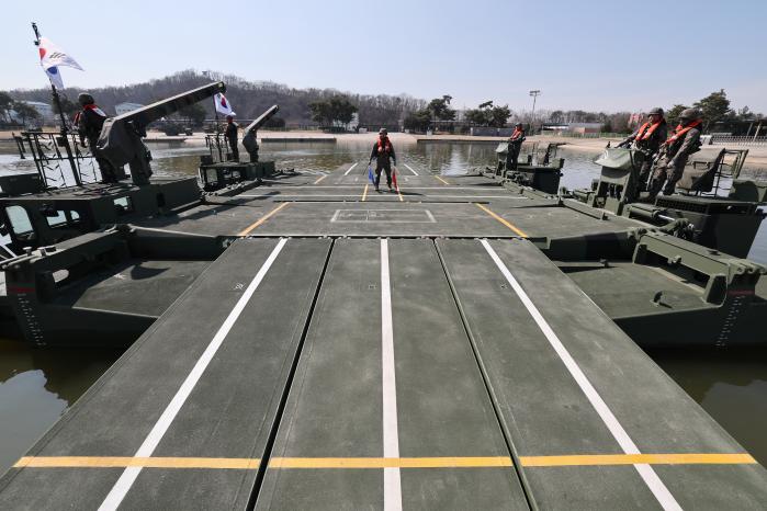 유도 인원 수신호 : 문교 구축을 마친 수룡 위에서 유도 인원이 수신호로 기동장비의 진입을 돕고 있다.