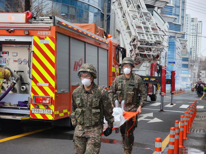 육군53보병사단 울산여단 장병들이 25일 ‘2026년 READY KOREA 훈련’에서 고층 건물 화재 상황을 가정해 환자를 들것으로 옮기고 있다. 부대 제공