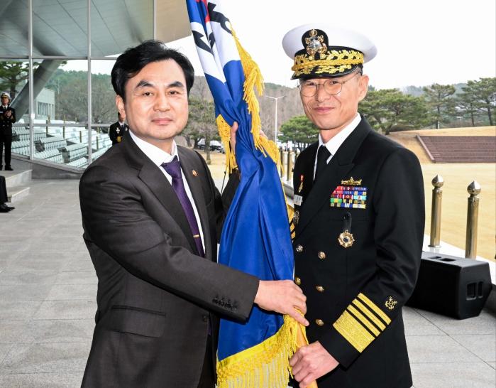 25일 계룡대 대연병장에서 거행된 제39대 해군참모총장 취임식에서 안규백(왼쪽) 국방부 장관이 김경률 신임 해군참모총장에게 해군기를 수여하고 있다. 해군 제공