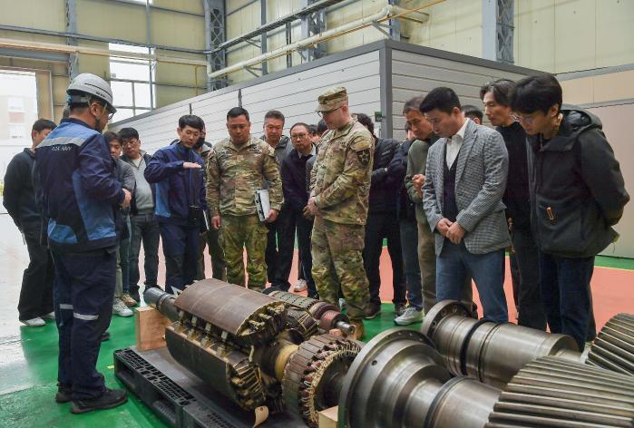 해군군수사령부 정비창과 미8군 관계관들이 25일 정비창 기계·의장직장에서 대형 발전기 회전자 수리부속을 둘러보며 3D프린팅 분야 상호협력방안을 논의하고 있다. 사진 제공=최혜진 하사