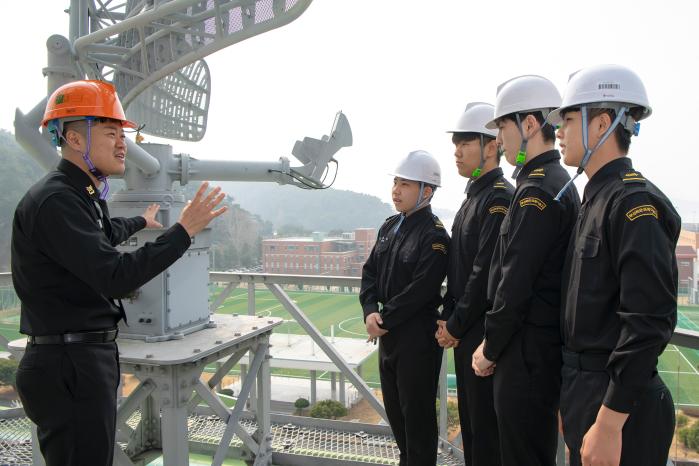 해군교육사령부 정보통신학교 김지혁(왼쪽) 교관이 부산해군과학기술고 해군전기전자과 1학년 학생들에게 GPS-200K에 대해 설명하고 있다. 사진 제공=홍성민 중사