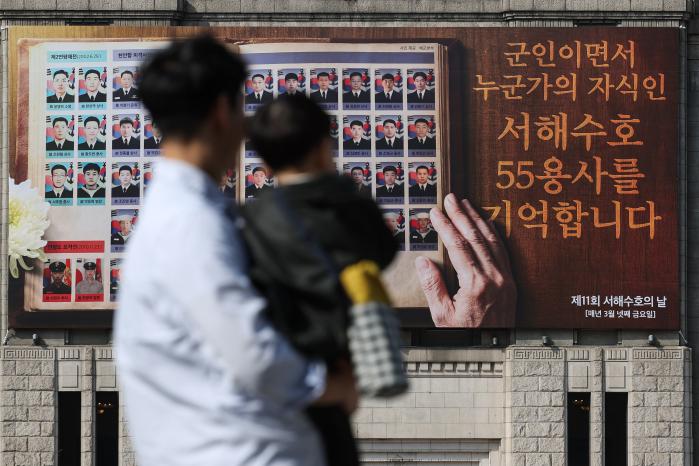 제11회 서해수호의 날을 앞둔 25일 서울 중구 서울도서관 꿈새김판에 서해수호 55용사의 사진과 추모 메시지가 걸려 있다. 이윤청 기자